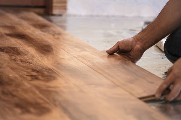Bathroom and Kitchen Remodeling Near Arcadia, Phoenix, AZ Man installing wood flooring in home.