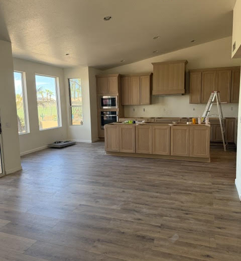 Kitchen remodeling progress at an AZ1 Builders project in PebbleCreek, Goodyear, with cabinetry, an island, hood surround and wood-look flooring