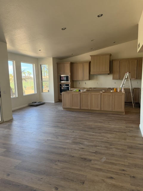 Kitchen remodeling progress at an AZ1 Builders project in PebbleCreek, Goodyear, with cabinetry, an island, hood surround and wood-look flooring